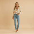 woman wearing butterfly print ruffle blouse with long sleeves shown in full front view outfit
