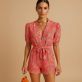 woman wearing printed summer jumpsuit with belted waist shown in full front view outfit