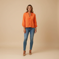 woman wearing ruffle detail blouse with lightweight structure shown in full front view outfit